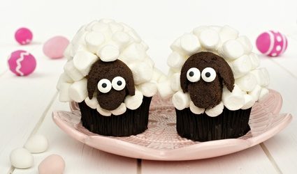 Cute spring sheep cupcakes on pink plate with Easter eggs